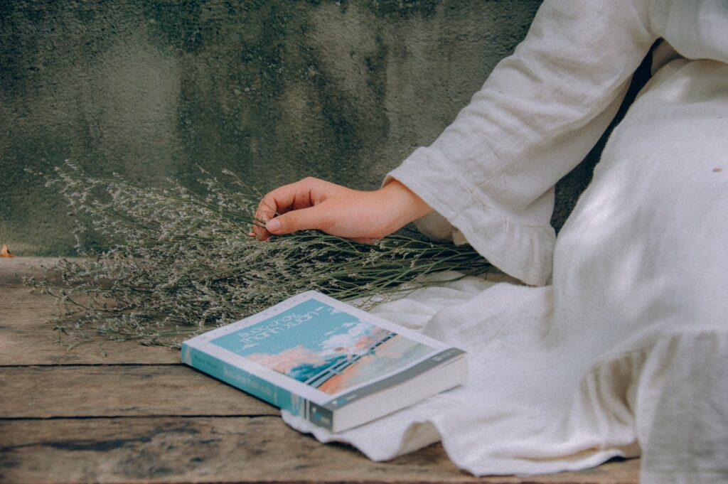 blue and white book beside woman wearing white dress